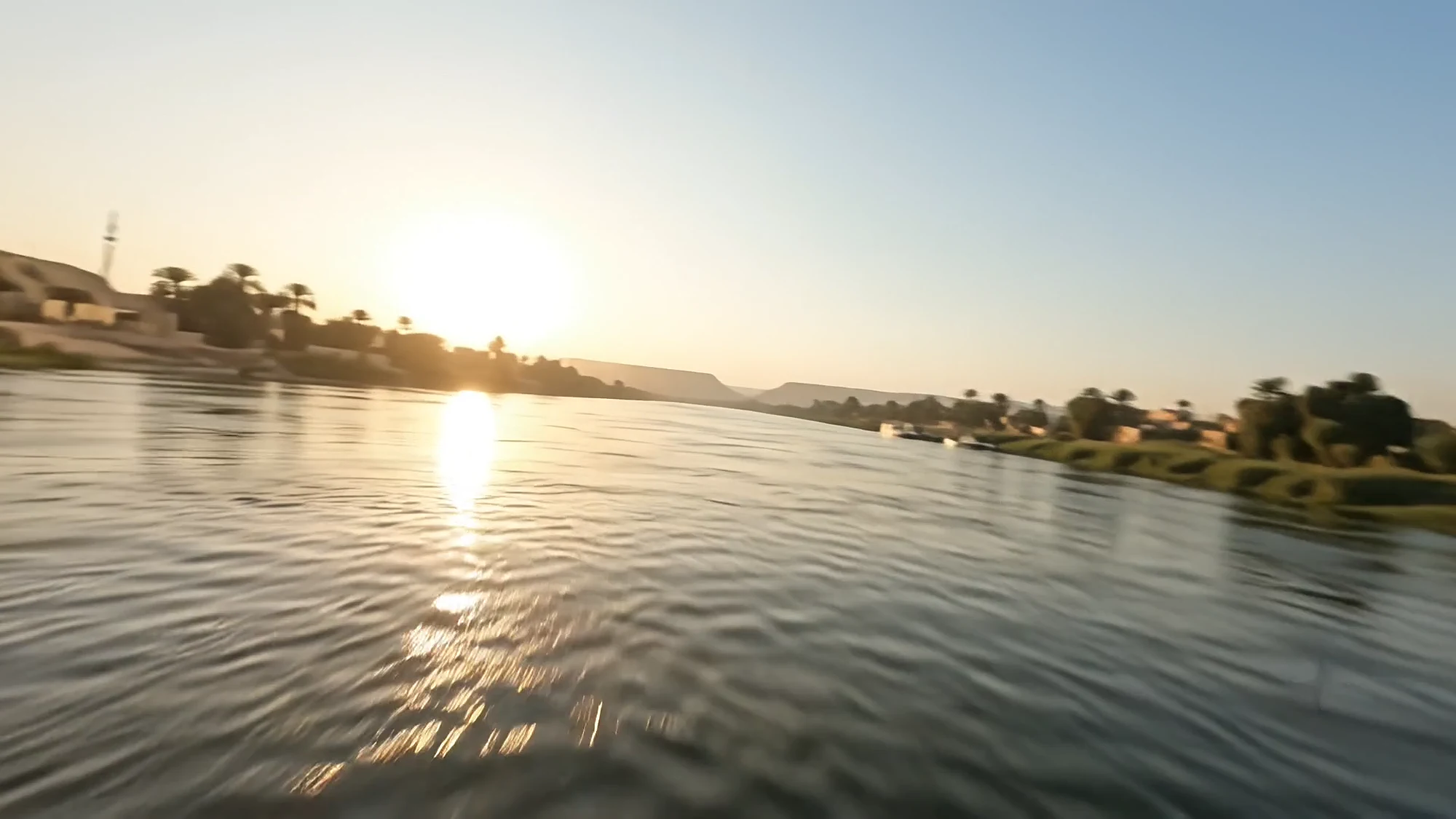The sun rises over the Nile and its palms