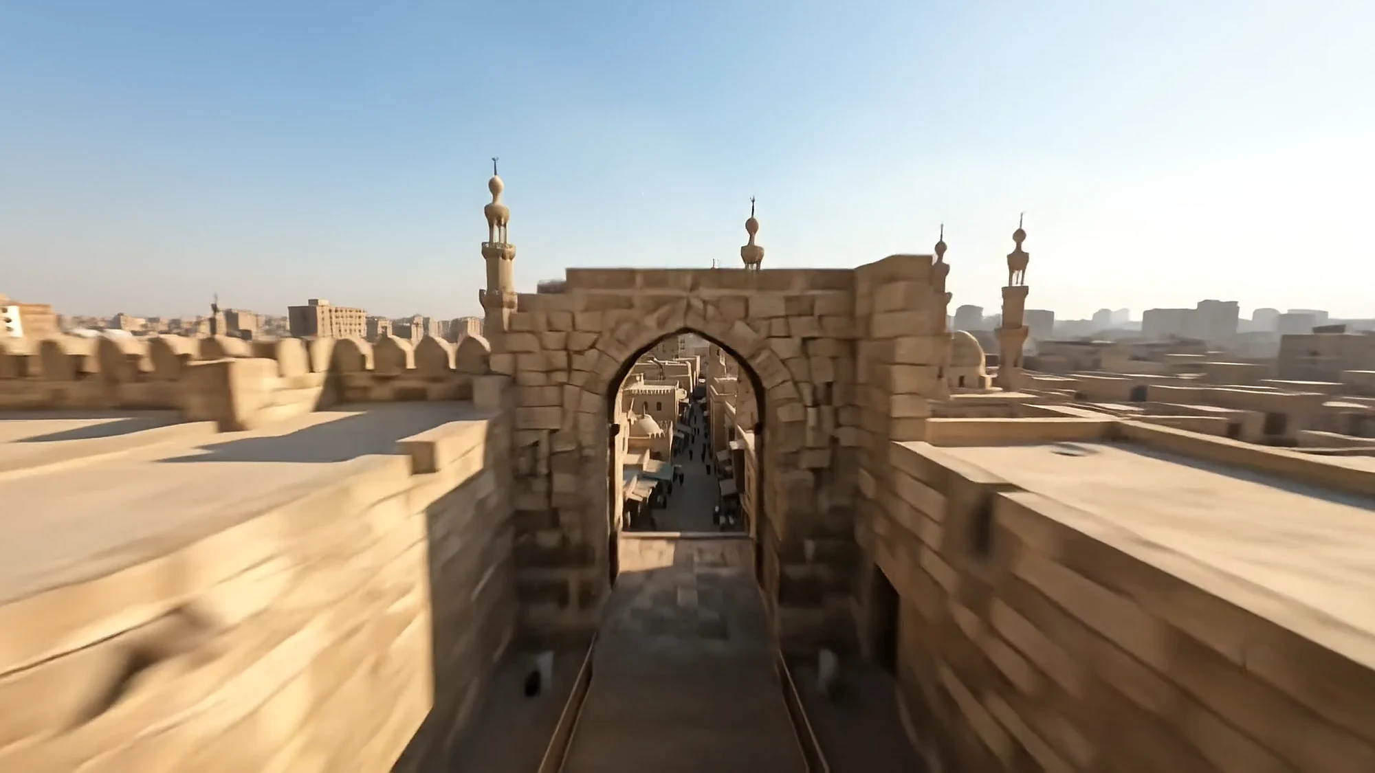 A medieval city gate and minarets over the rooftops of old Cairo