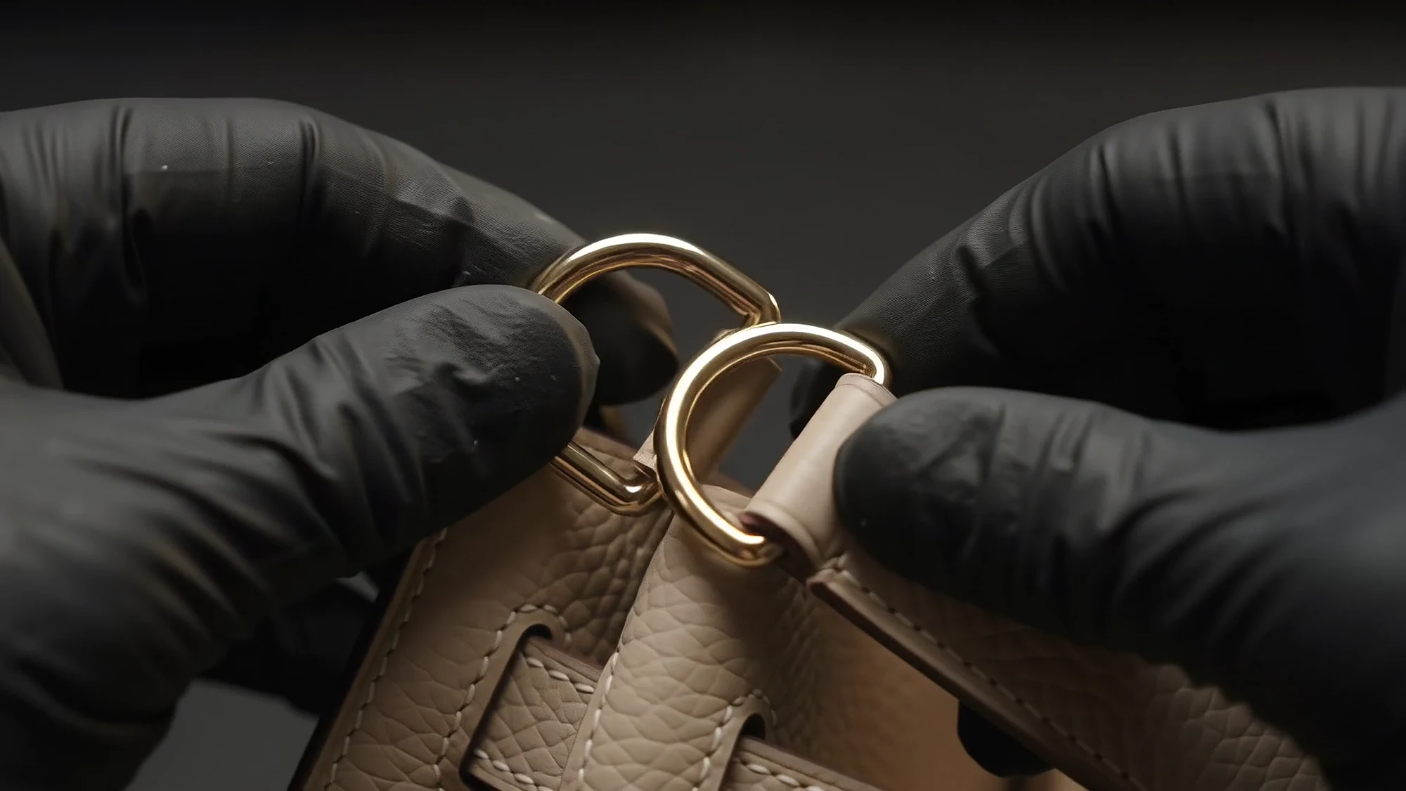 Gold D-rings threaded through the strap