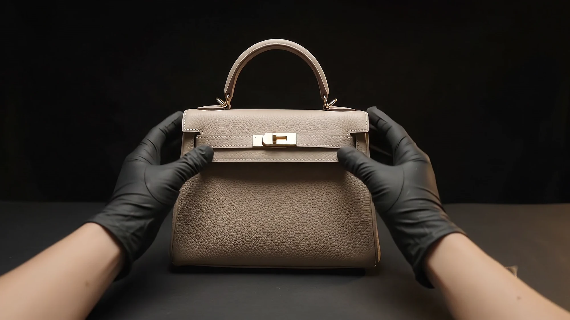 The finished mini bag held between two gloved hands