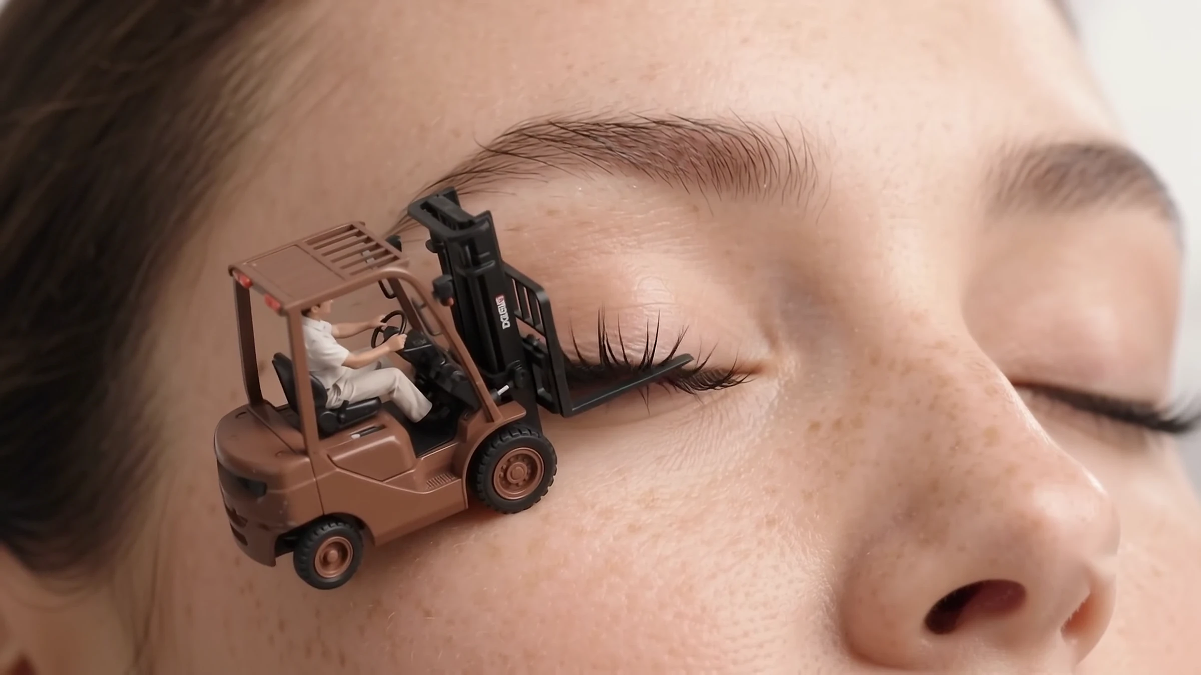 The forklift lifting a strip of lashes into position beside the eye